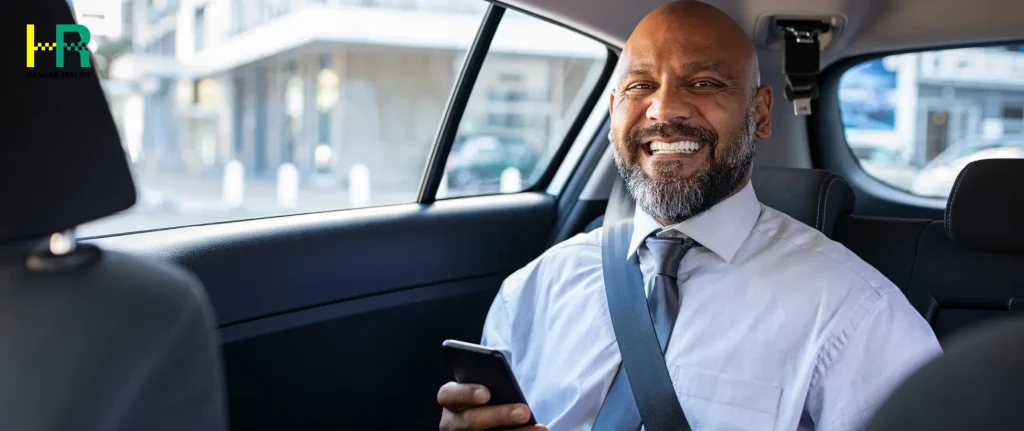A passenger smiling inside a taxi, showcasing the comfortable and reliable service for Taxi Schiphol Den Haag.